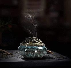 Decorative incense burner with smoke on a dark background