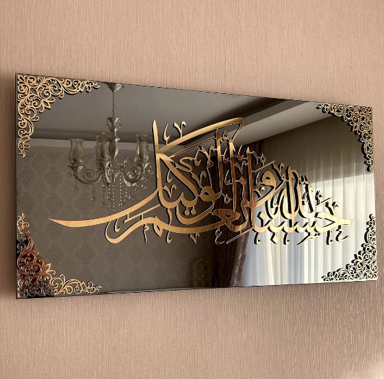 Decorative mirror with gold Arabic calligraphy and intricate border on a beige wall.