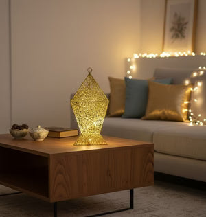 Decorative lamp on a wooden coffee table in a cozy living room with soft lighting.